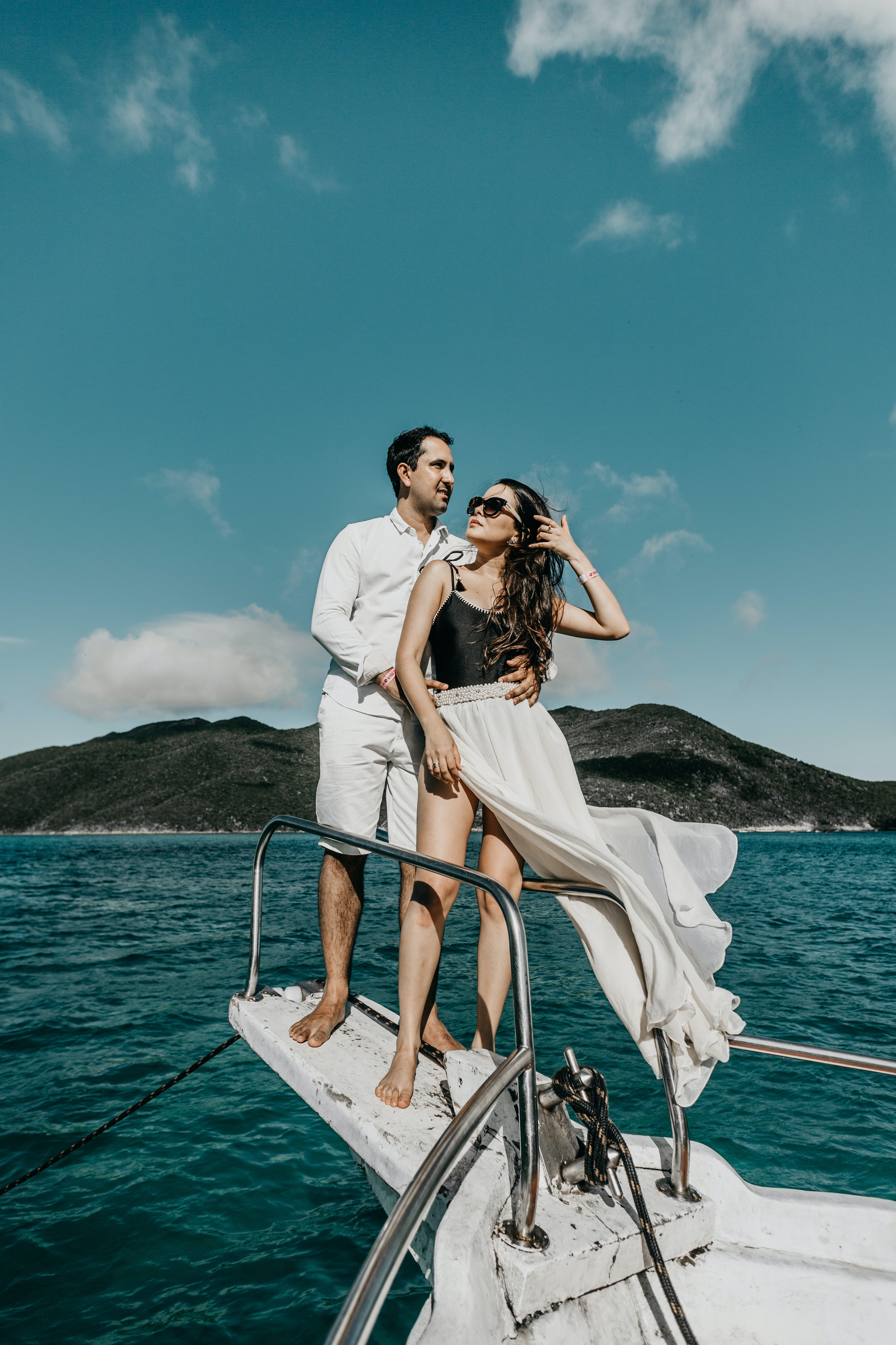 couple standing at the end of their yacht