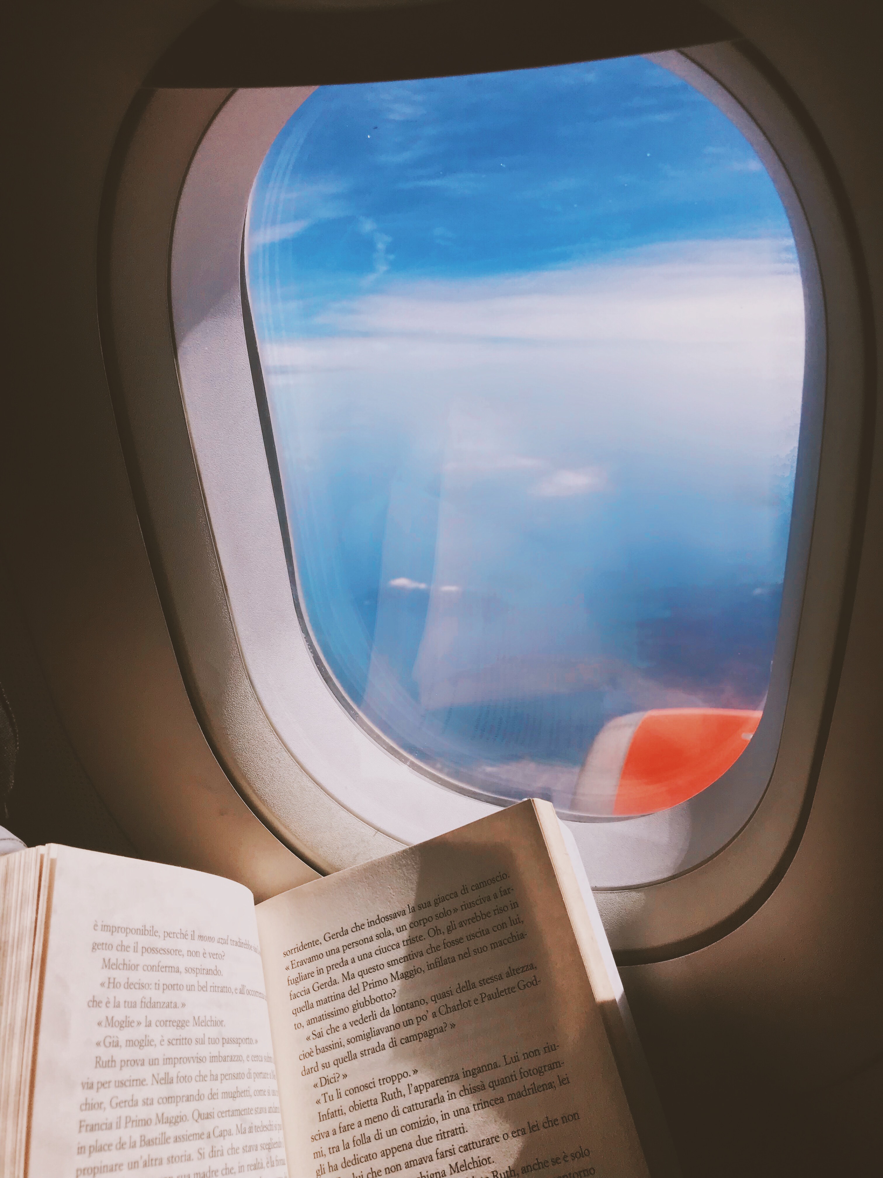 airplane window with a book 
