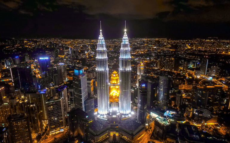 Aerial night view of KLCC or Petronas Towers, also known as the Petronas Twin Towers are twin skyscrapers in Kuala Lumpur. 
