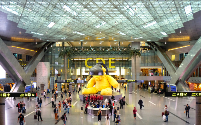Giant yellow teddy bear installation in Hamad International Airport duty-free hall center