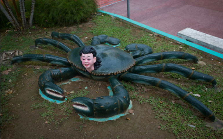 A statue of a woman in a crab body at Haw Par Villa