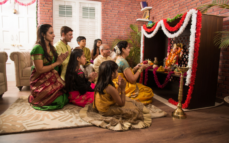 Family performing Ganesh puja or aarti at home 