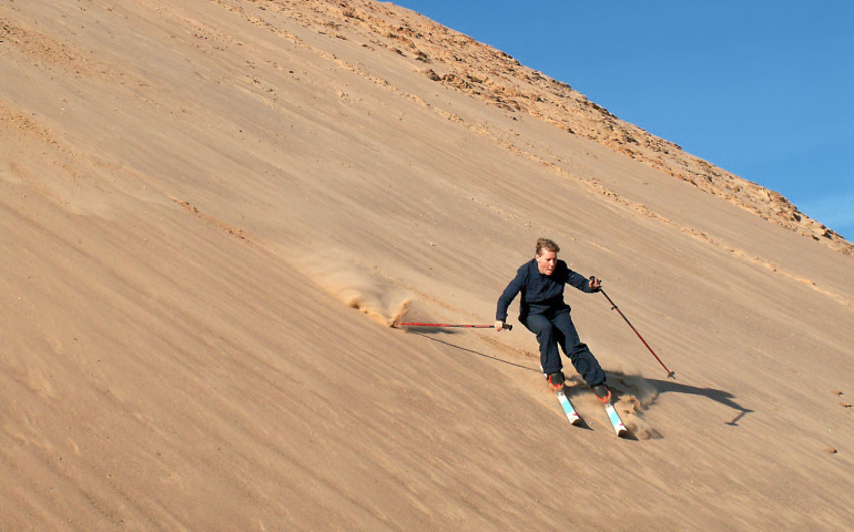 Sand skiing down dunes in desert