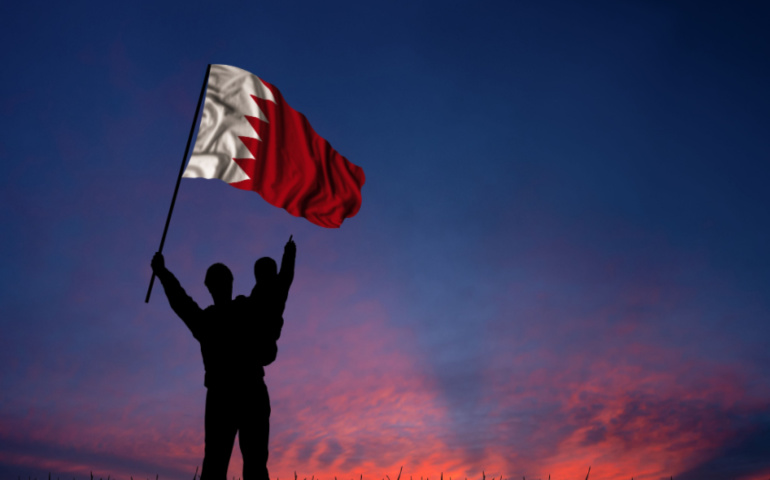 Father and son hold the flag of Bahrain 