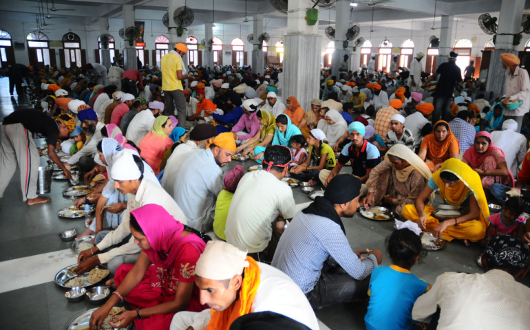 Pilgrims eating food in the food area at the Harimandir Sahib, the Golden temple complex in Amritsar