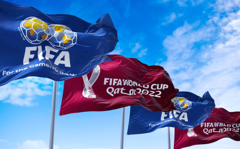 Flags with FIFA and Qatar 2022 World Cup logo waving in the wind