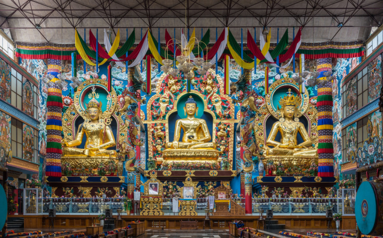  Inside Padmasambhava Vihara of Namdroling Buddhist Monastery. The golden statues of guru Padmasambhava, Buddha and Amitabha in front, surrounded by extensive decor.