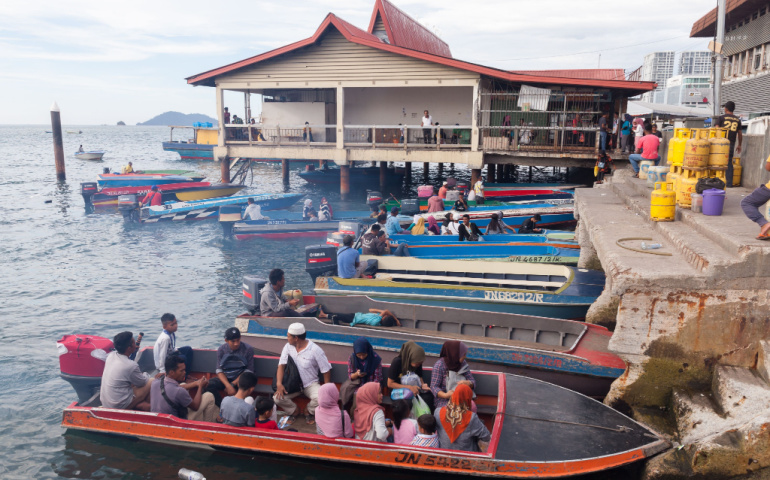  Motorboats full of passengers are moored behind KK Fish Market 