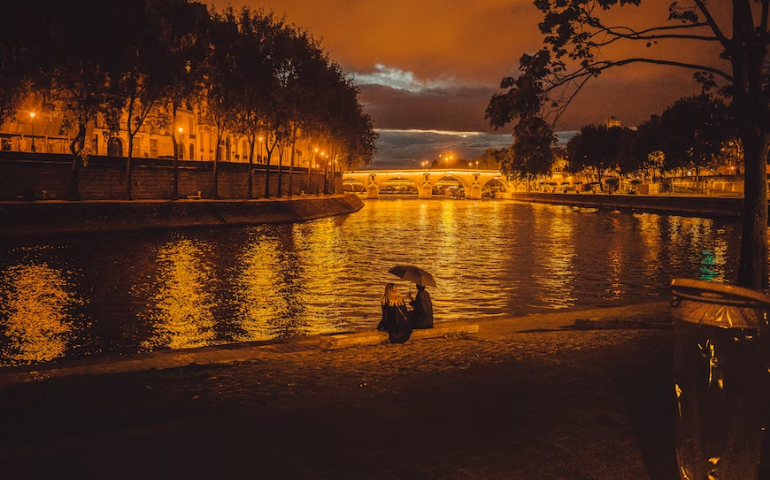 Couple sitting by the River Seine, Paris