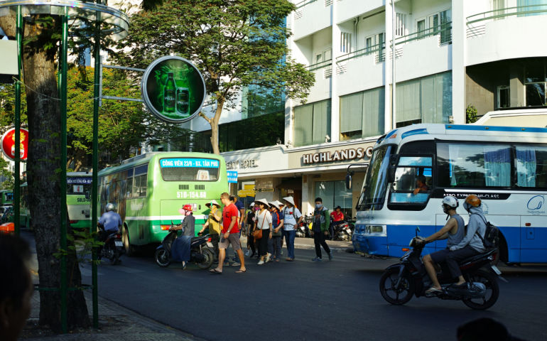 Tourist is crossing the street in downtown of Ho Chi Minh City, Sai Gon.
