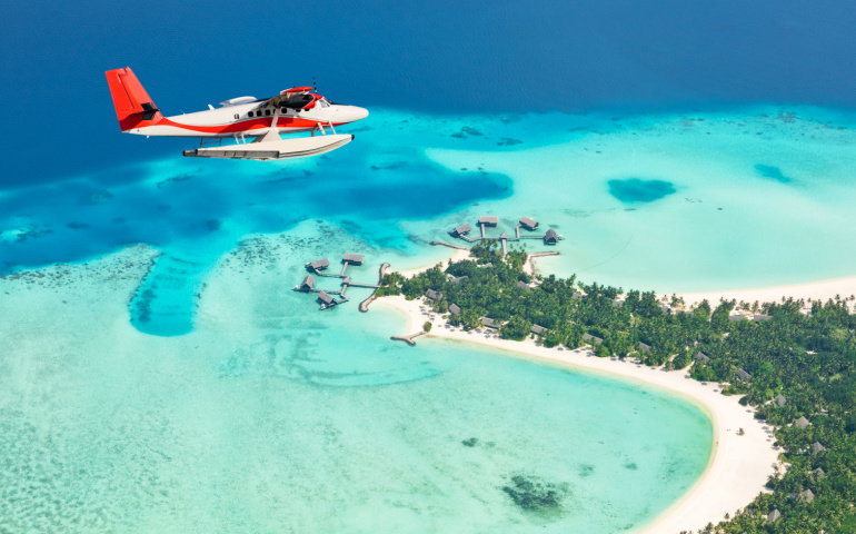 Sea plane flying above Maldives islands