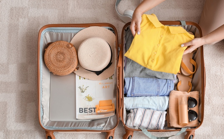 Woman packing suitcase at home.
