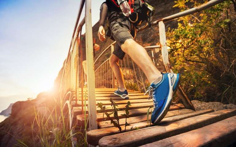 Walking on a wooden bridge at sunset. 