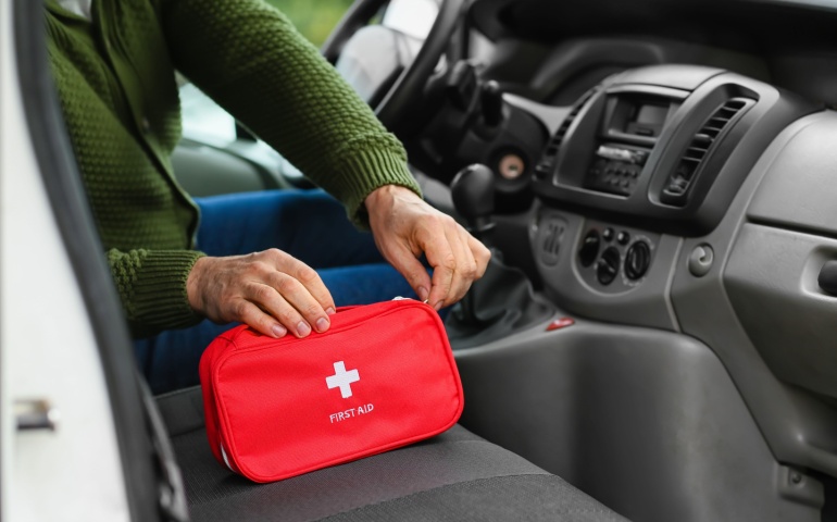 Man with first aid kit in car
