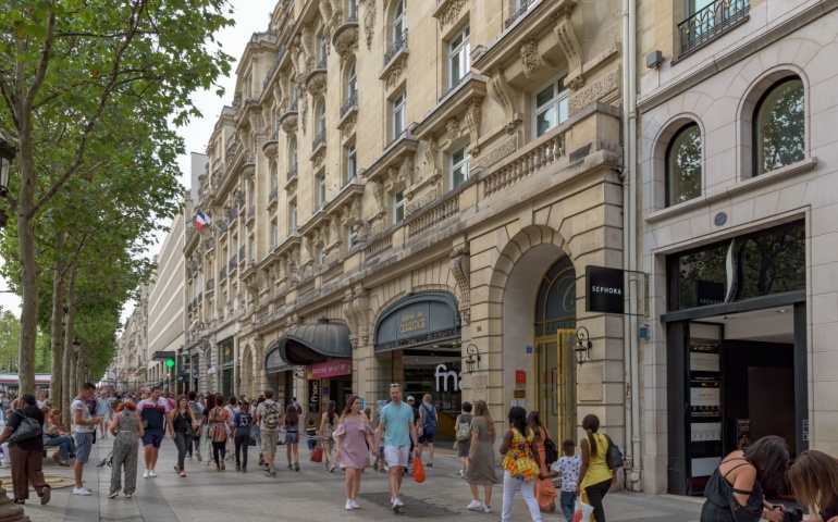 Paris, France. August 2019. Crowds of local people and tourists on the Avenue des Champs Elysees. The Avenue is one of the most famous streets in the world for upscale and luxury shopping.
