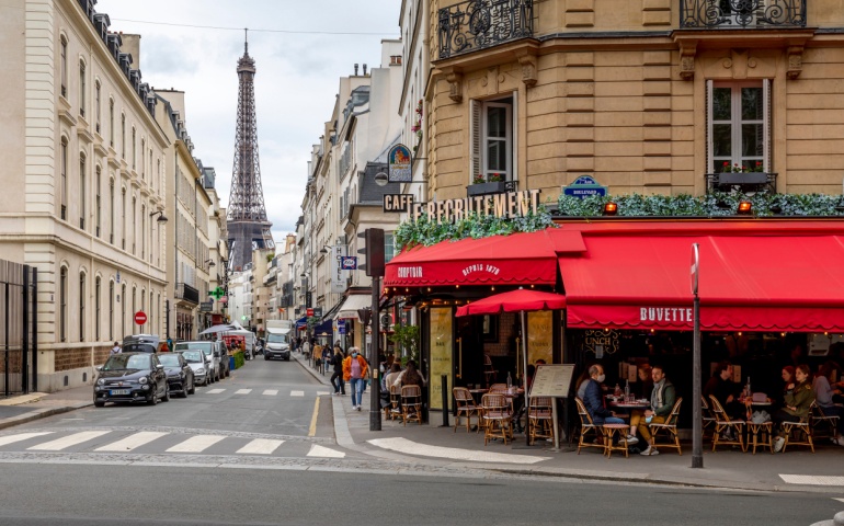 Famous Parisian Cafe with the Eiffel Tower in background in Paris. 
