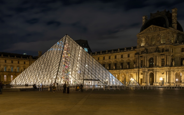 The Louvre Glass Pyramid illuminated at night. 
