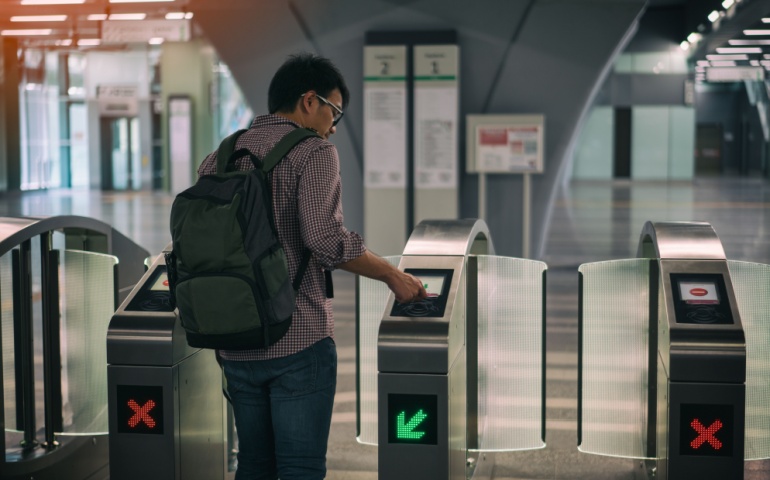 A young man scanning his pass at the entry of the MRT in Kuala Lumpur.