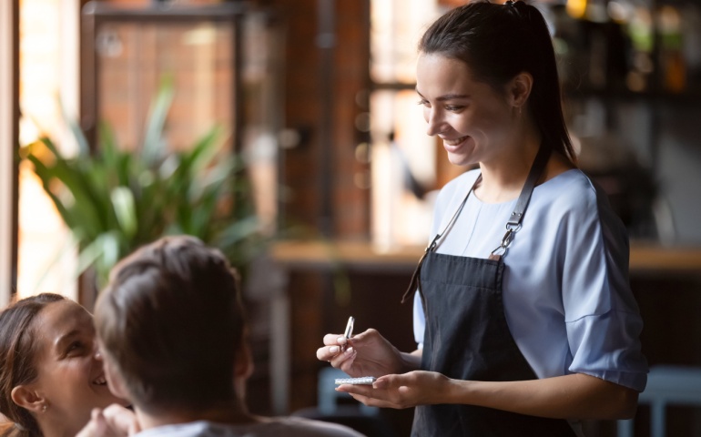 Waiter taking orders from customers