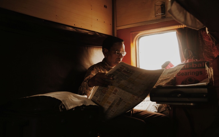 Man reading newspaper on the train