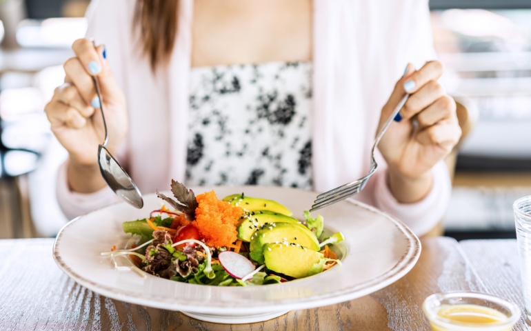 Woman eating salad in a restaurant