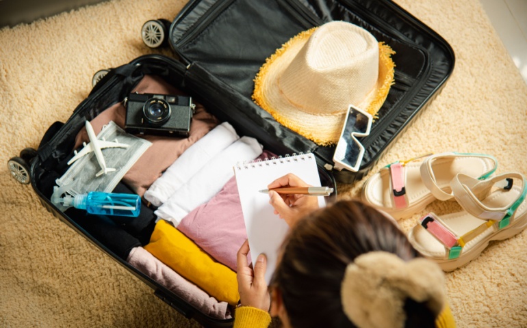 Woman preparing a checklist of things to pack