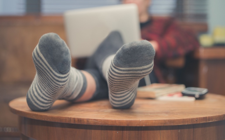 Woman using her table as a footstool.