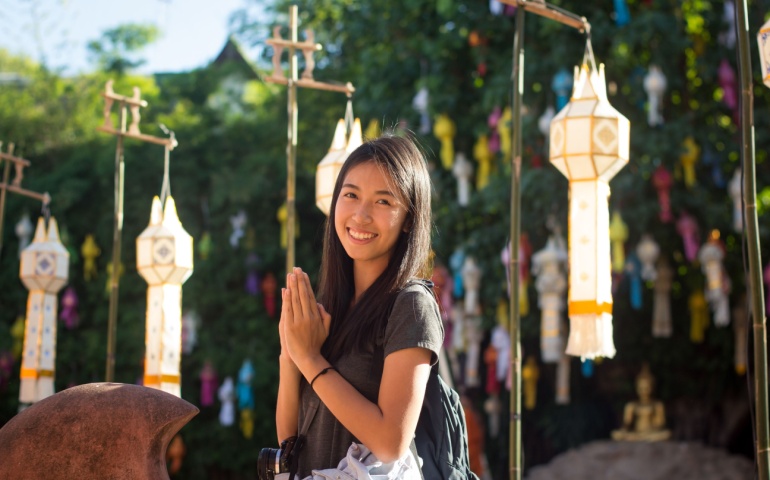 Tourist doing the Wai pose in Thailand