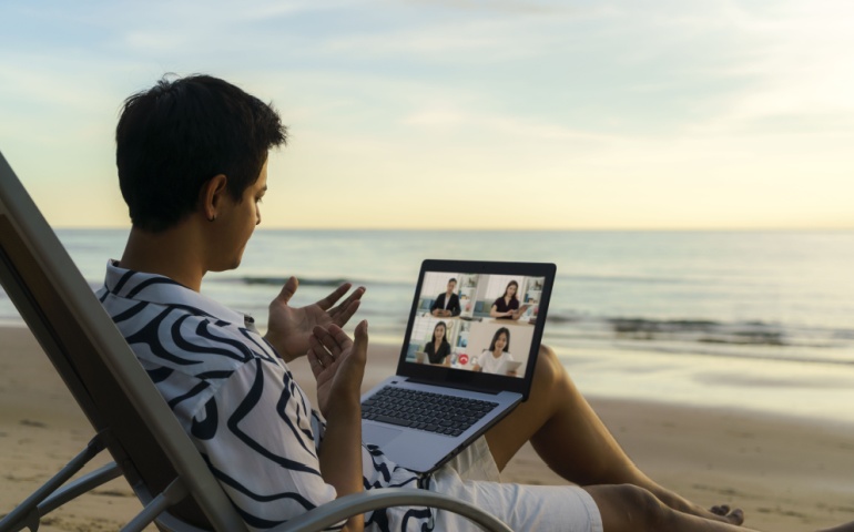 A man attending a conference meeting on the beach