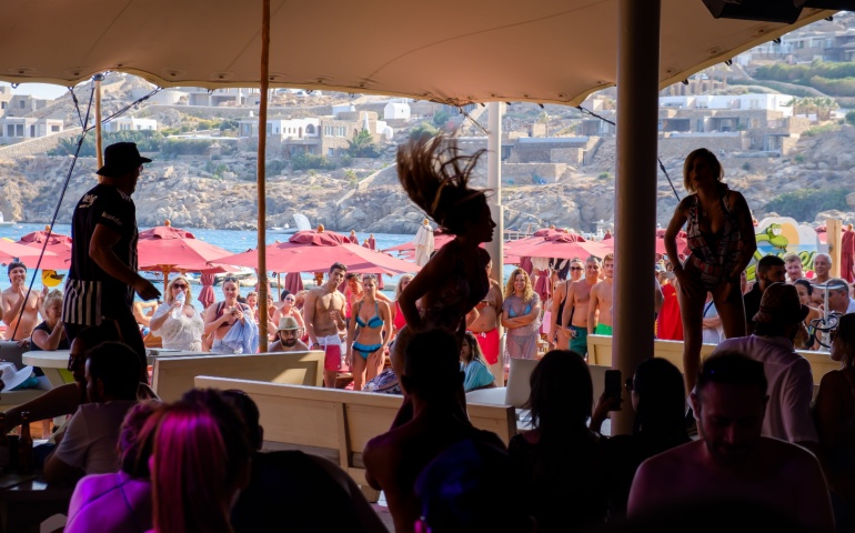 Entertainers dancing at a beach bar in Mykonos.