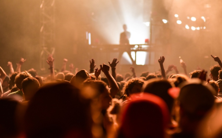 A crowd of people dancing on the beach.