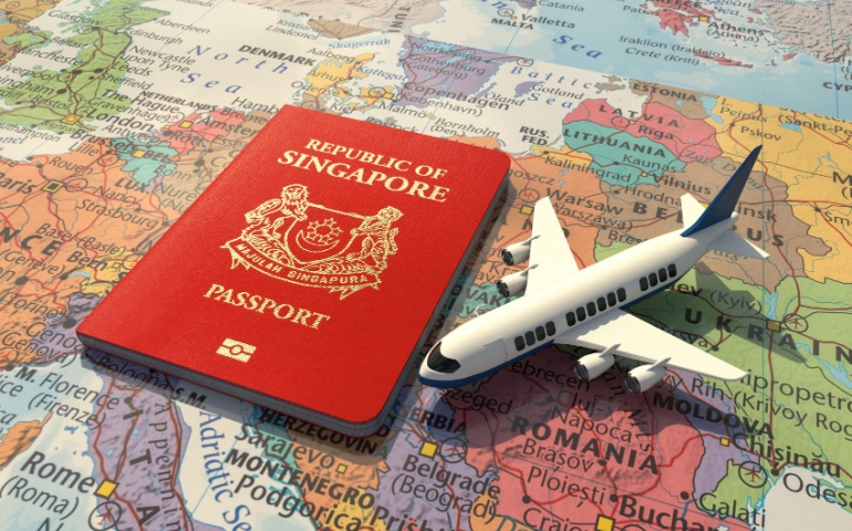 Singapore Passport and a toy aeroplane on the world map.