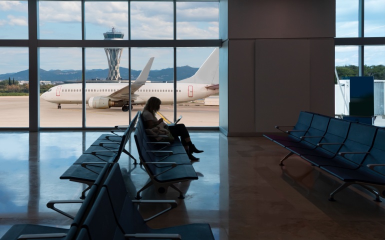 Silhouette of Young Woman Working on Laptop and Waiting for Flight